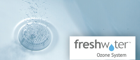 Close-up of water flowing into a drain. Text on the right reads "freshwater Ozone System" with a blue water drop in the "w."